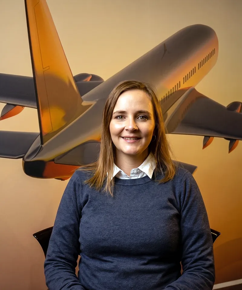Woman smiling with airplane backdrop