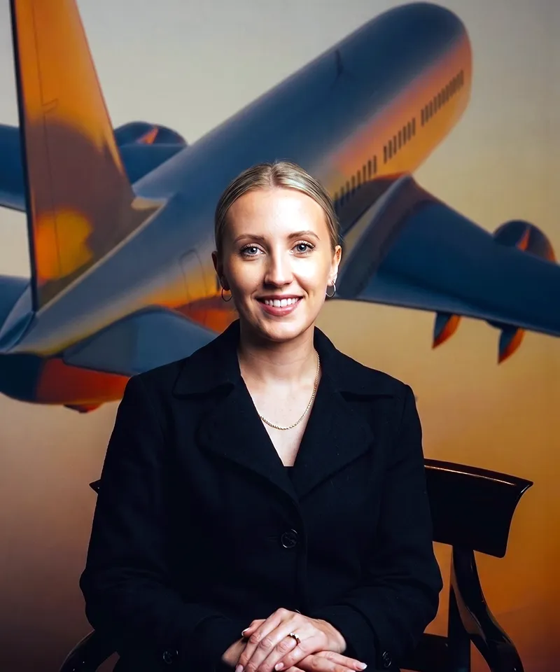 Businesswoman seated with large aeroplane in background